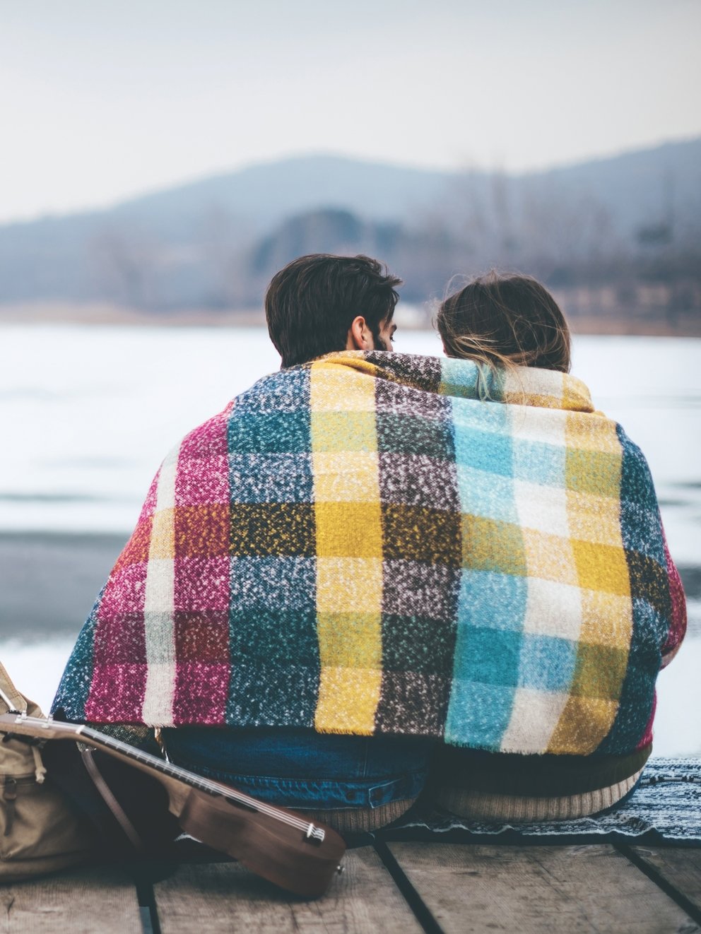 Couple on cold winter day in nature, having fun